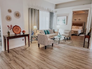 A living room with a sofa, armchair, coffee table, and a console table with decorative items. - Beautiful home near Englewood Beach (Rotonda West)