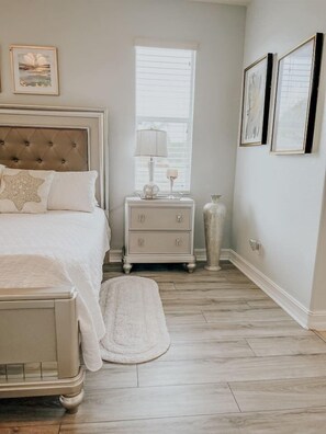 A bedroom with a bed, bedside table, lamp, and a large vase. - Beautiful home near Englewood Beach (Rotonda West)
