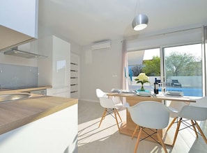 Eine moderne Küche mit einer Holz Arbeitsplatte und weißen Stühlen.