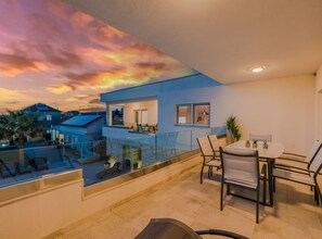 A modern balcony with a glass railing, a dining area with chairs and a table, and a view of the sunset. - Villa Marija Exclusive Stay - Two Bedroom Apartment with Terrace 4 (Sukosan)