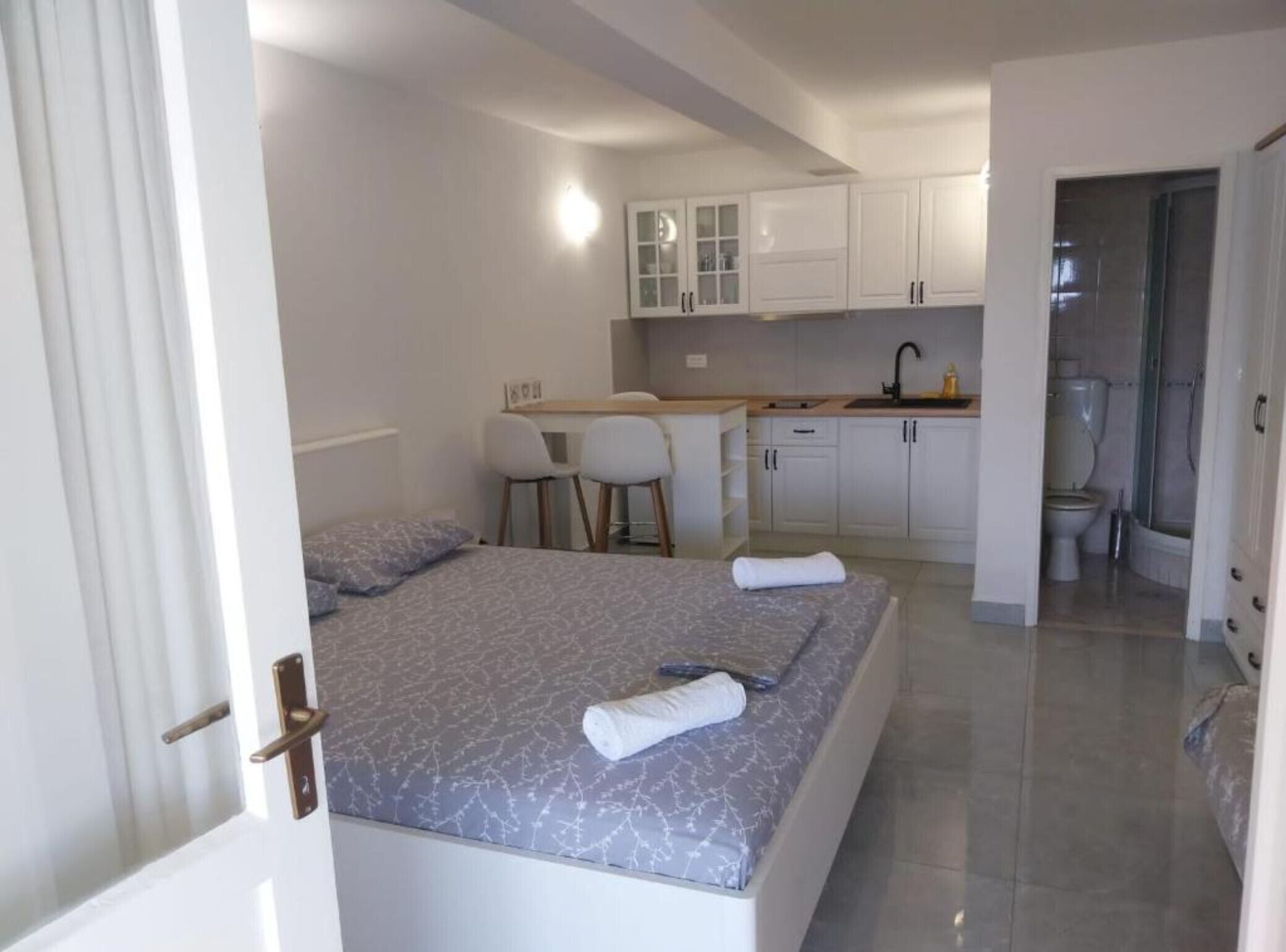 Un dormitorio con cama, escritorio y baño.
