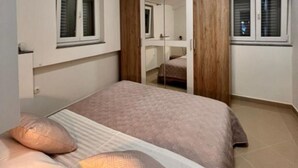 Ein Schlafzimmer mit einem Bett, Kissen, einem Kleiderschrank und einem Spiegel.