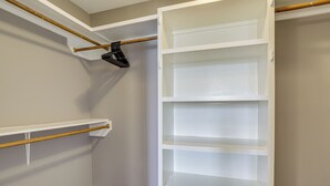 A closet with white shelves and a wooden rod. - Riverfront Ventress Home w/ Patio & Shared Pier (Ventress)