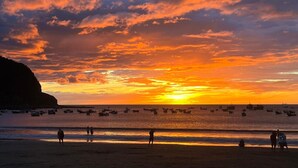A sunset over a beach with boats and people. - Casa Altavista 3 Bedroom 4 Bath Oceanview Home with 2 Pools, Patios, and Balconies (San Juan del Sur)