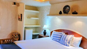 A bedroom with a wooden bed, a ceiling fan, a nightstand, and a shelf with decorative items. - Casa Altavista 3 Bedroom 4 Bath Oceanview Home with 2 Pools, Patios, and Balconies (San Juan del Sur)