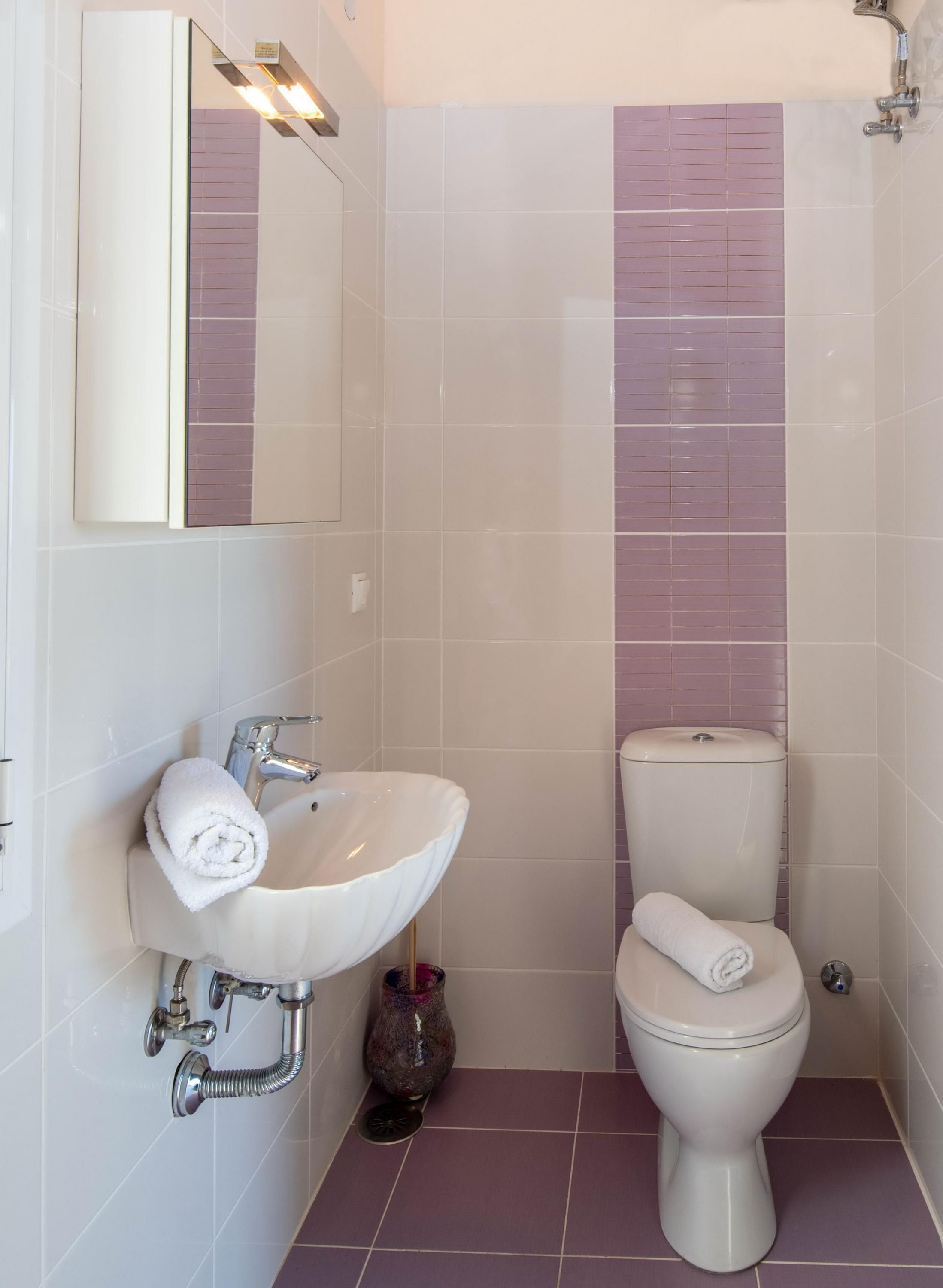A bathroom with a white sink, a toilet, and a mirror.