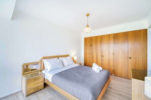 Ein Schlafzimmer mit einem hölzernen Bett, einem Nachttisch, einem Kleiderschrank und einer Deckenleuchte.