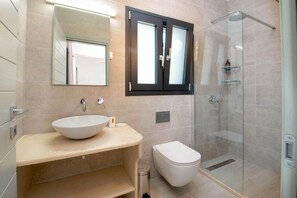 Une salle de bain moderne avec un grand miroir, un lavabo et des toilettes.