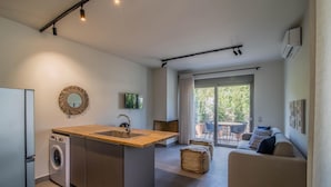 Uma cozinha moderna com máquina de lavar embutida, uma ilha central com pia e uma área de jantar com mesa e cadeiras.