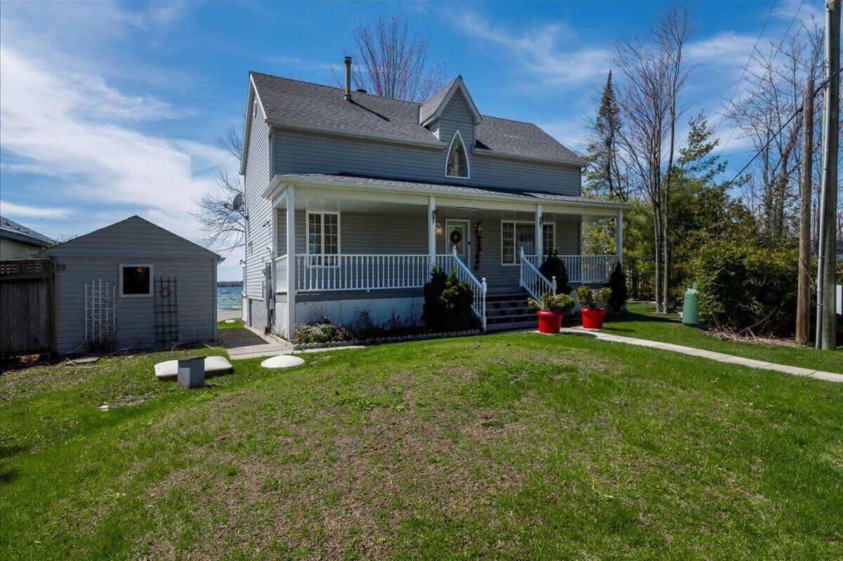A two-story house with a front porch, a small attached garage, and a well-maintained lawn.