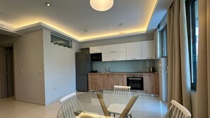 Une cuisine moderne avec des armoires blanches, un four encastré et un four à micro-ondes.