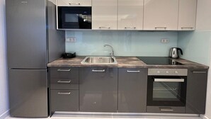 A modern kitchen with a built-in microwave, stainless steel sink, and a dishwasher. - Suite 5 - Elpida Luxury Suites (Nydri)
