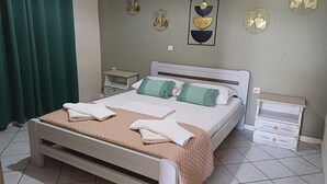 A bedroom with a bed, two bedside tables, a nightstand, and decorative wall art. - Casa Mare Apartment - Agios Ioannis Lefkada (Lefkada)