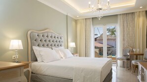 Quarto bem decorado com uma cama grande, mesas de cabeceira, um candelabro e vista para o exterior.