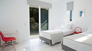 A modern bedroom with two beds, a red chair, and a large window. - Villa Anticlea Villas Harriet, with sea view! (Ligia)