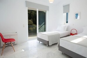 A modern bedroom with two beds, a red chair, and a large window. - Villa Anticlea Villas Harriet, with sea view! (Ligia)
