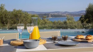A breakfast setup with a view of a pool and mountains. - Villa Anticlea Villas Harriet, with sea view! (Ligia)