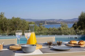 A breakfast setup with a view of a pool and mountains. - Villa Anticlea Villas Harriet, with sea view! (Ligia)