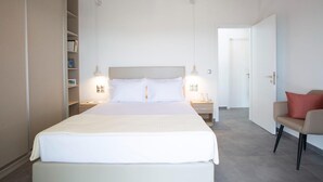 A neatly arranged hotel room with a large bed, bedside tables, a wardrobe, and a chair. - Aloft Luxury - Villa Lefkia with heated pool (Apolpena)