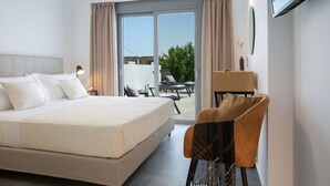 A hotel room with a large bed, a chair, a desk, and a TV mounted on the wall. - Aloft Luxury - Villa Lefkia with heated pool (Apolpena)