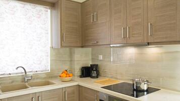 A kitchen with wooden cabinets, a double sink, a coffee maker, and a stove.
