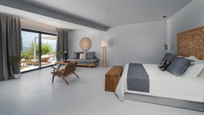 Een moderne slaapkamer met een groot bed, een houten bankje, een bank en een stoel. Er is een groot raam met gordijnen, een lamp en een wandklok.