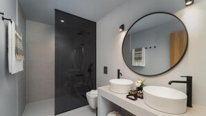 Ein modernes Badezimmer mit einer Duschkabine aus Glas, einem runden Spiegel und zwei Waschbecken.