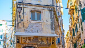 Un carrer estret amb una taverna anomenada "TAVERNIA" a la cantonada.
