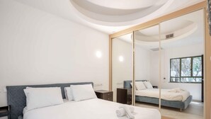 A modern hotel room with a large bed, a bedside table, a mirror, and a window. - Ben Yehouda Jonquille (Tel Aviv-Yafo)