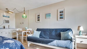 A bedroom with a bed, a desk, a chair, a nightstand, and a wall with framed pictures. - Steps to Sandy Beach! Oceanfront Old Orchard Gem (Old Orchard Beach)