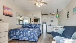 A bedroom with a bed, a dresser, a nightstand, a ceiling fan, and a kitchenette area with a refrigerator and microwave. - Steps to Sandy Beach! Oceanfront Old Orchard Gem (Old Orchard Beach)