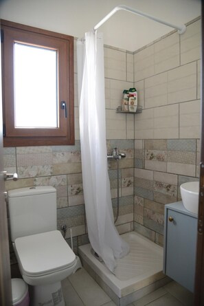 Ein Badezimmer mit Dusche, Toilette und Waschbecken.