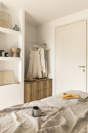Ein Schlafzimmer mit einem Bett, einem Holzschrank, einem Kleiderschrank und einer Tür.
