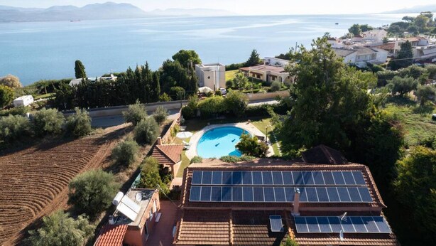 Quartiere residenziale con piscina, pannelli solari e vista sul mare.
