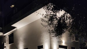 A modern building with a dark metal fence, illuminated by wall-mounted lights. - Minimal Condo Trikala town (Trikala)