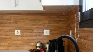 A modern kitchen with stainless steel sinks, wooden countertops, and a coffee maker. - Minimal Condo Trikala town (Trikala)