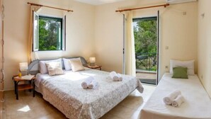 A bedroom with two beds, a window, an air conditioning unit, and a balcony. - Nikis Country House - Lefkada BnB  Private Parking (Ligia)