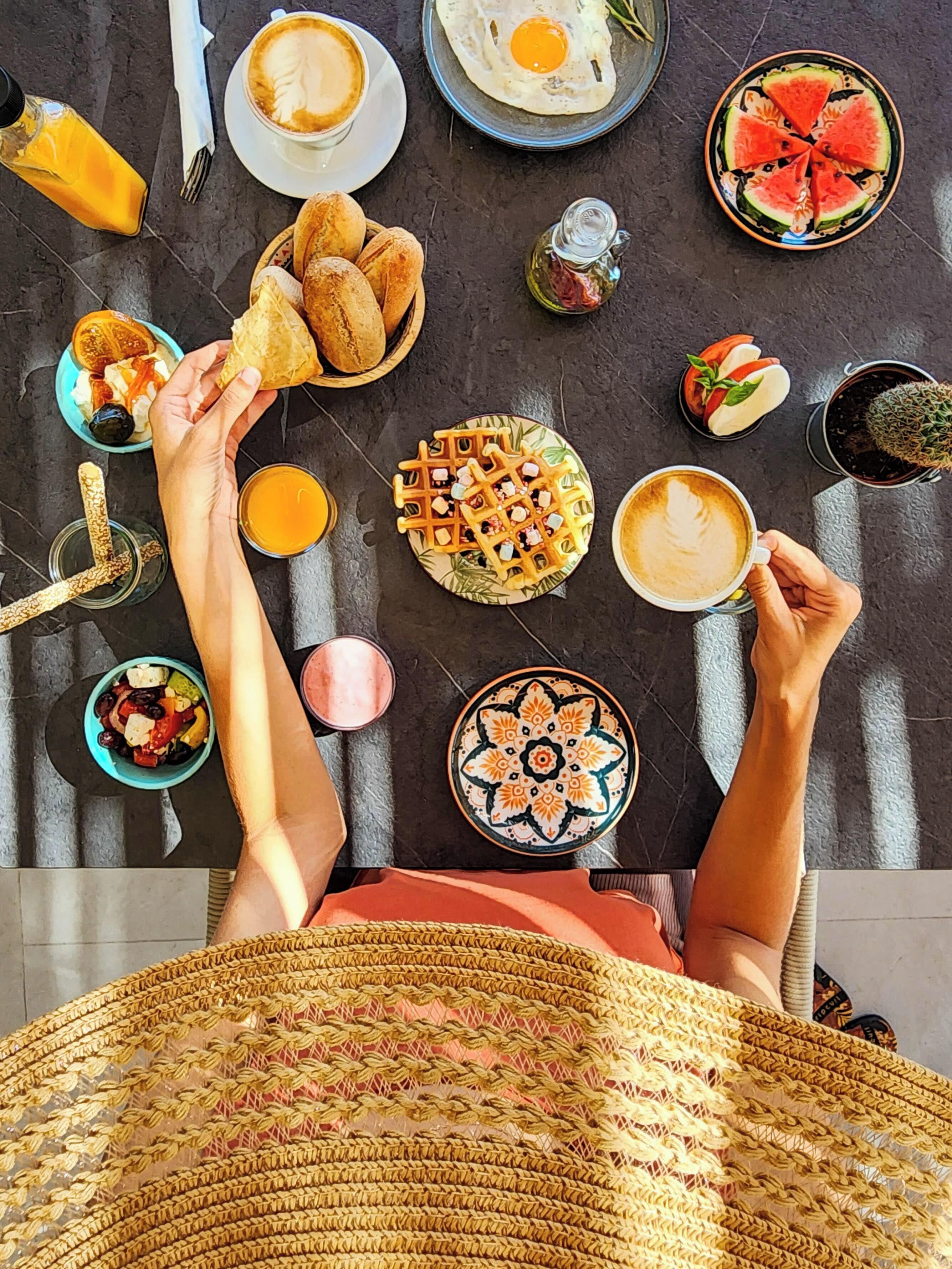 A table with breakfast items including waffles, eggs, and fruit.