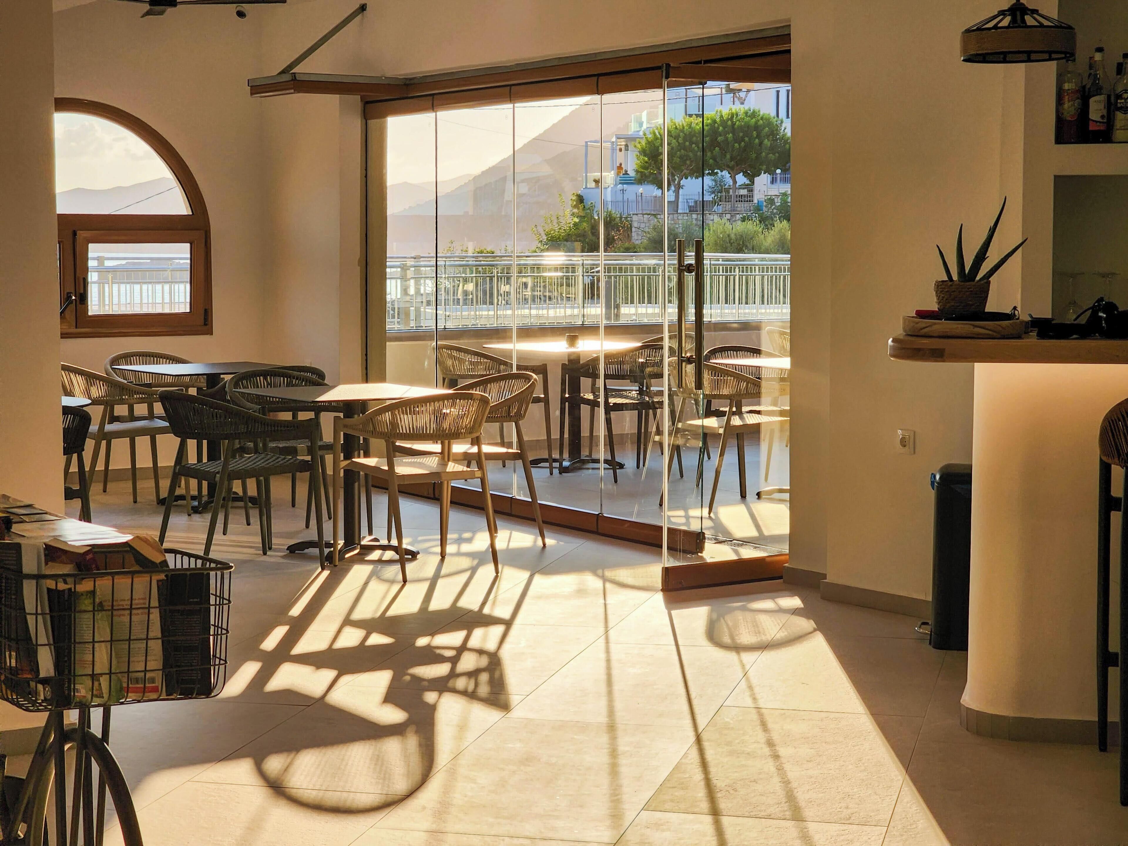 A modern interior with a dining area, large windows, and a view of the outside.