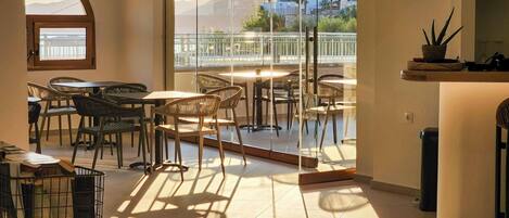 A modern interior with a dining area, large windows, and a view of the outside.