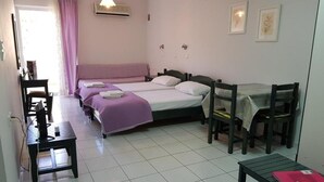 Ein Schlafzimmer mit zwei Betten, einem Schreibtisch, einem Sessel und einem Tisch.
