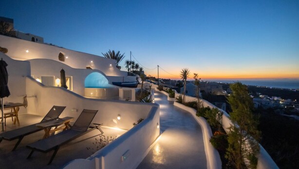 Un edificio moderno con techo curvo, asientos al aire libre y vistas a la costa.