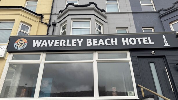 Une enseigne d’hôtel portant le nom « Waverley Beach Hotel » et un logo.