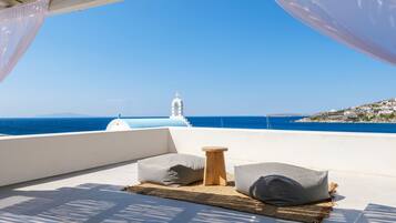 Una terraza con vistas al mar y un edificio blanco con una cruz en la parte superior.