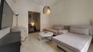 Une chambre à coucher moderne et minimaliste, dotée d’un grand lit, d’un canapé, d’un bureau et d ’une télévision.