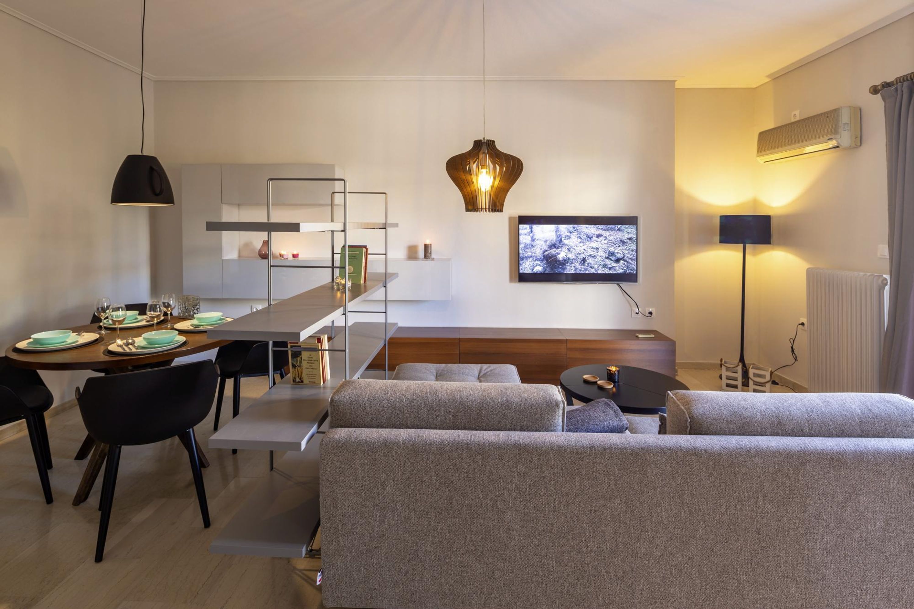 A modern living room with a sofa, dining table, and TV.