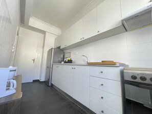 A modern kitchen with white cabinets, a stainless steel refrigerator, a coffee maker, and a stove. - Plato - Acropolis Residence Apartment (Athina)