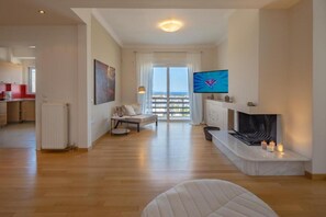 Un salon moderne doté d’un téléviseur, d’une cheminée et d’un balcon offrant une vue agréable.