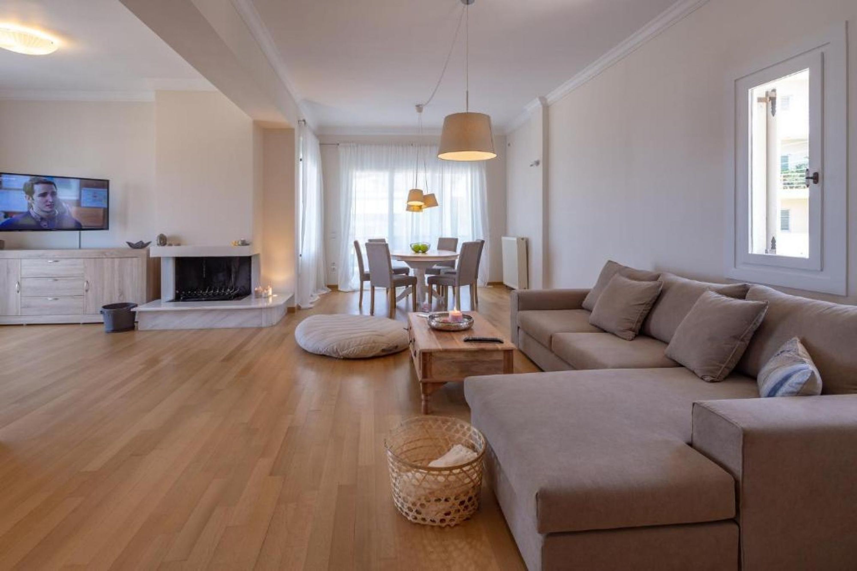 A modern living room with a sofa, a dining table, and a TV.