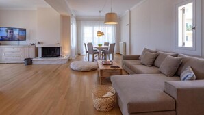 Un salon moderne avec un canapé, une table à manger et un téléviseur.